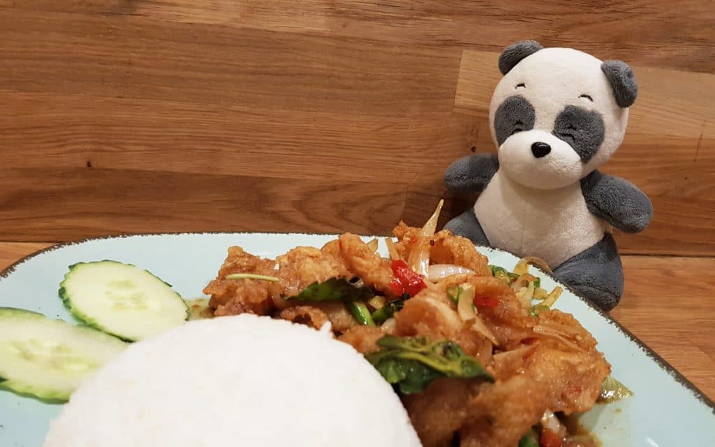 Mister Wong behind a plate of Thai food Ka Prao Pla Thod, deep fried fish with rice.