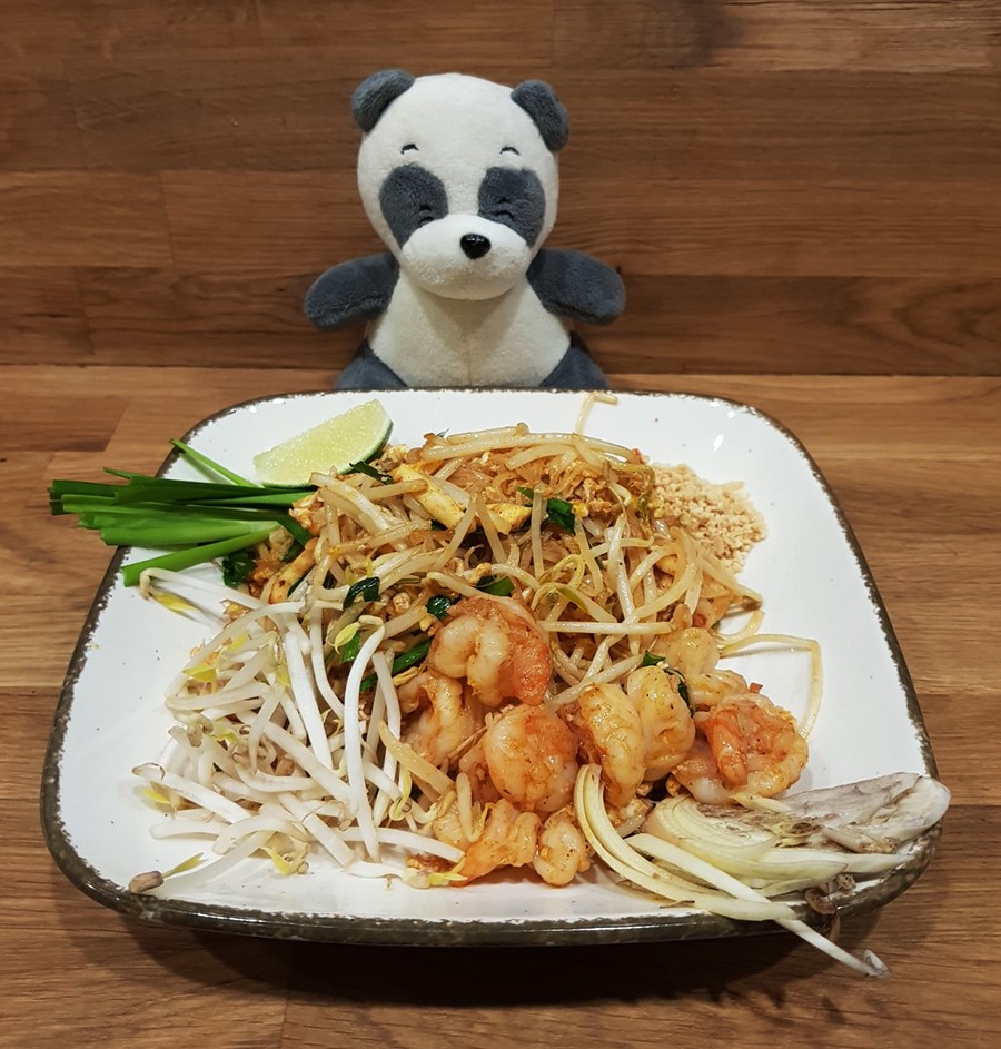 Mister Wong behind a plate of Thai food Pad Thai with shrimps